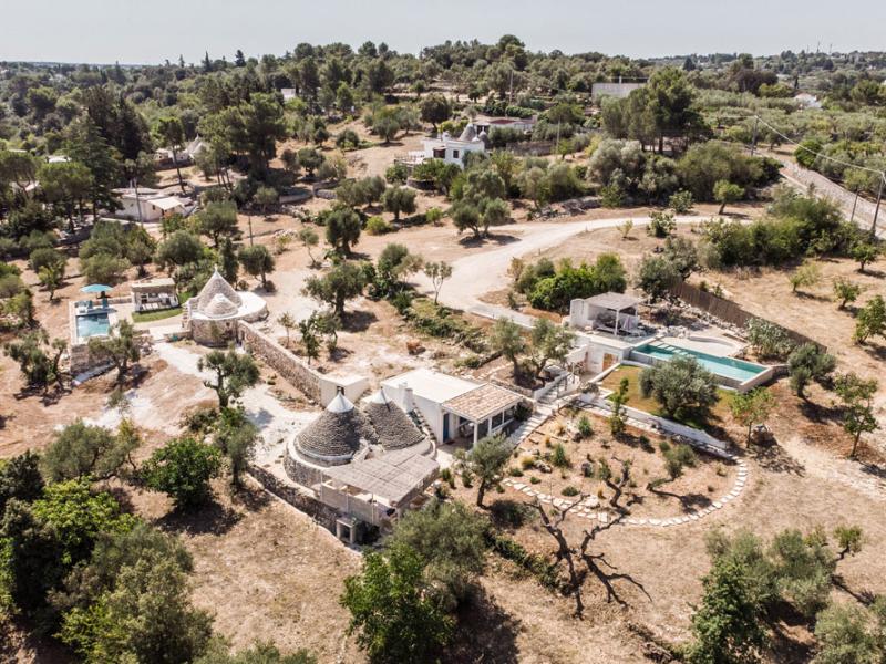 Trullo immerso nella campagna con piscina e vista panoramica.