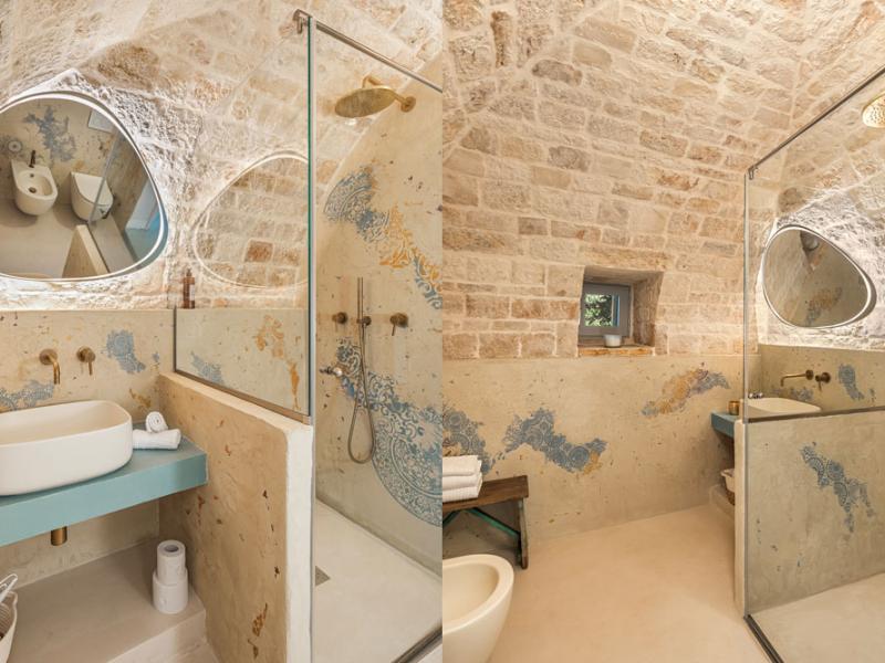 Bagno rustico con doccia moderna e lavandino in pietra.