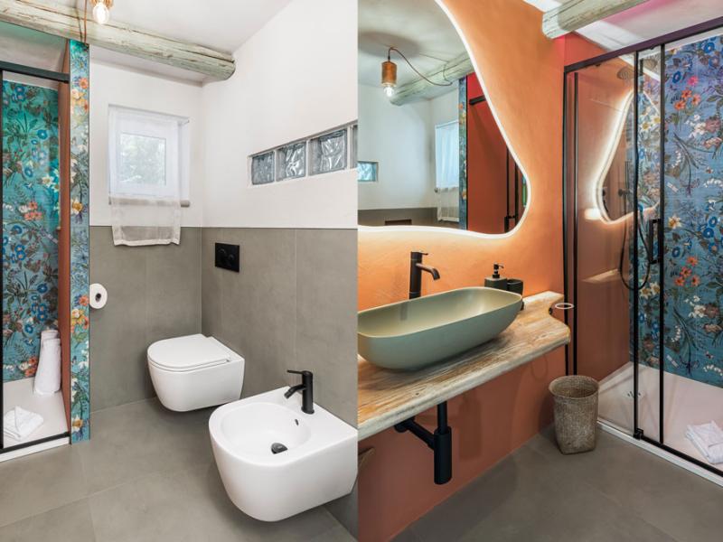 Bagno moderno con doccia, lavabo e wc, decorato con piastrelle floreali.